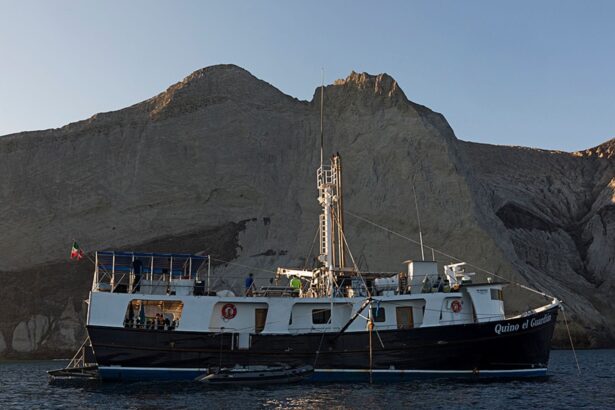 The Quino El Guardian liveaboard anchored beneath rugged desert mountains