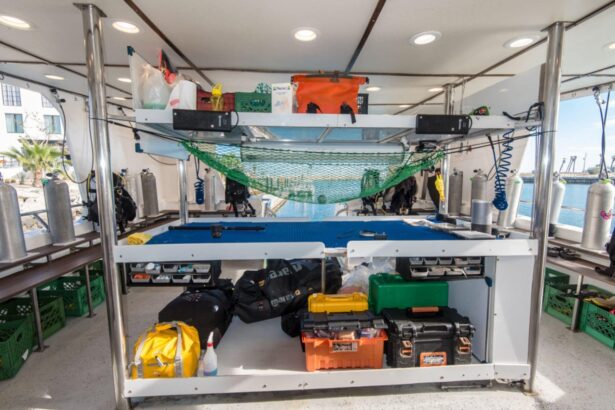 Scuba tanks and gear bags organized on the boat's dive deck racks
