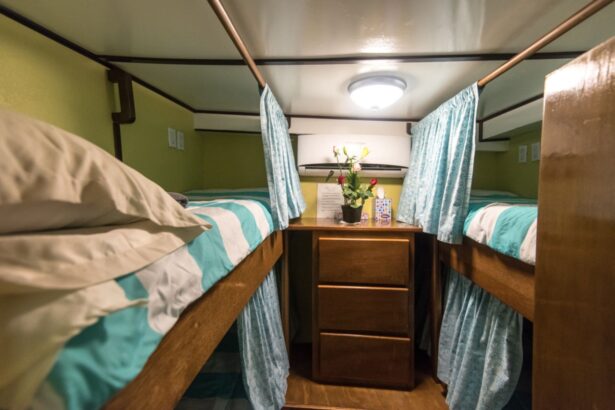 A bunk cabin with a small nightstand and fresh flowers aboard the boat
