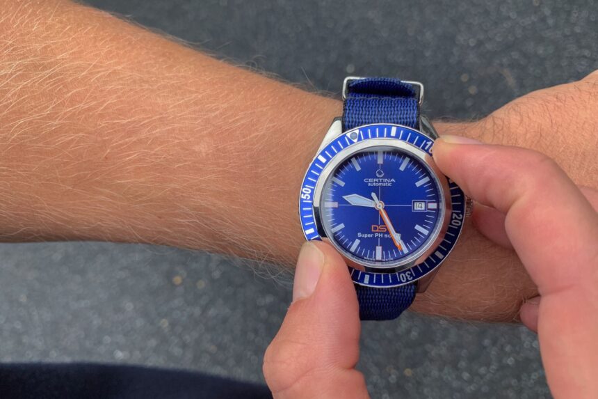 Our tester adjusting the blue Certina DS Super PH500M on the wrist outdoors