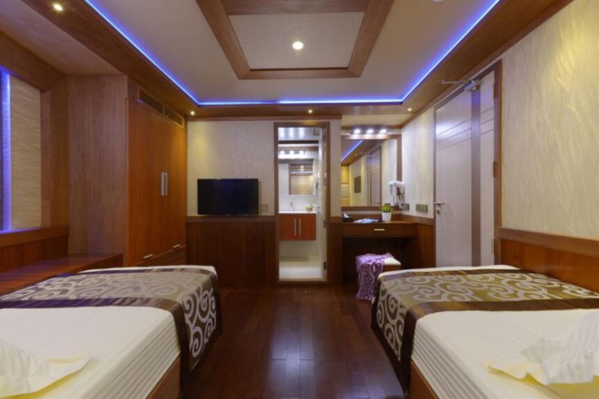 Twin bed cabin aboard the Maldives Blue Force One with a wall-mounted TV