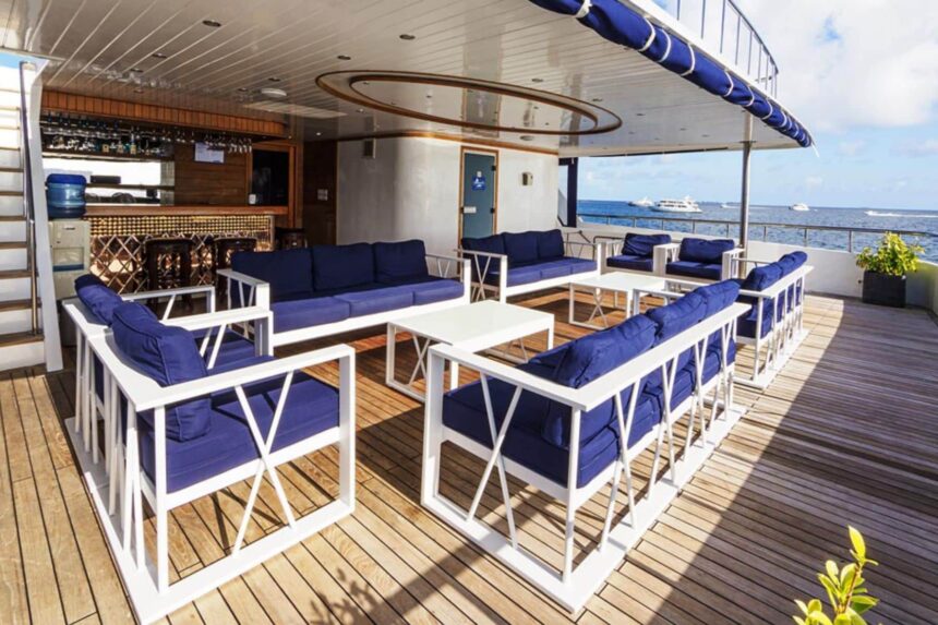 Blue upholstered lounge seating on the outdoor deck bar of a liveaboard