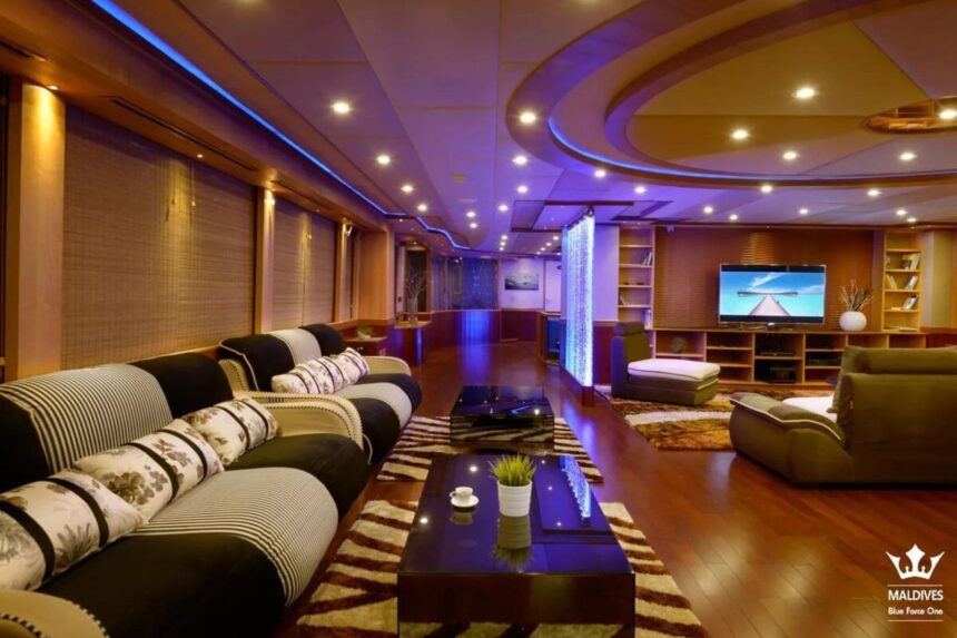 Lounge area aboard the Maldives Blue Force One with striped sofas and a TV
