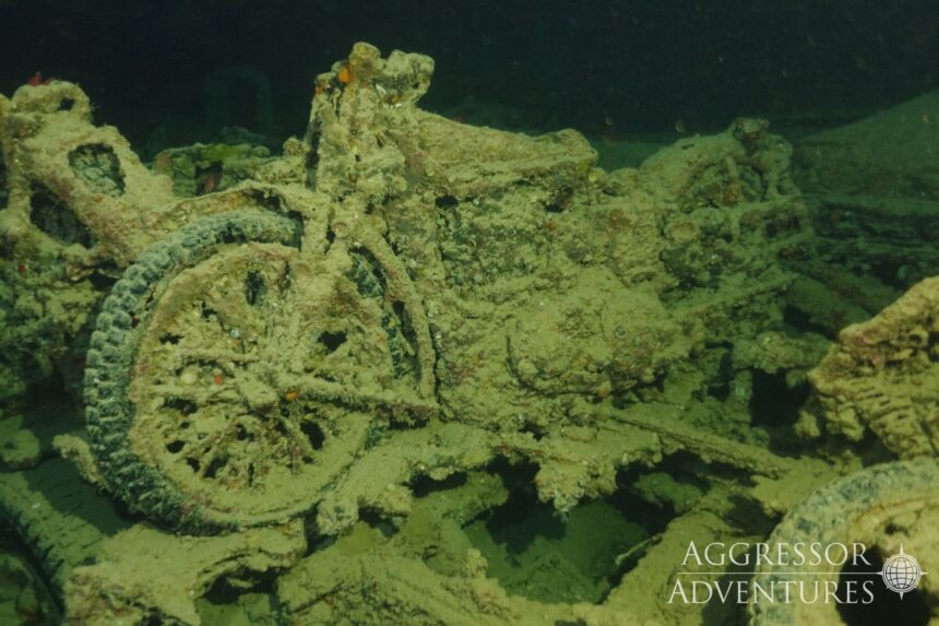 Corroded motorbike wreckage encrusted with growth inside the SS Thistlegorm wreck
