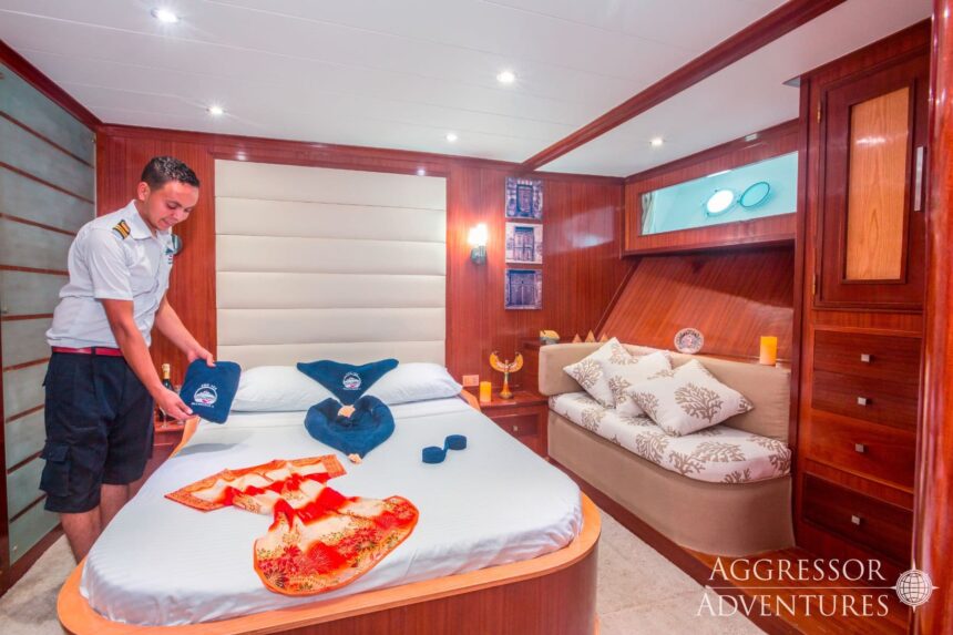 Crew member preparing a guest cabin bed aboard the Red Sea Aggressor II