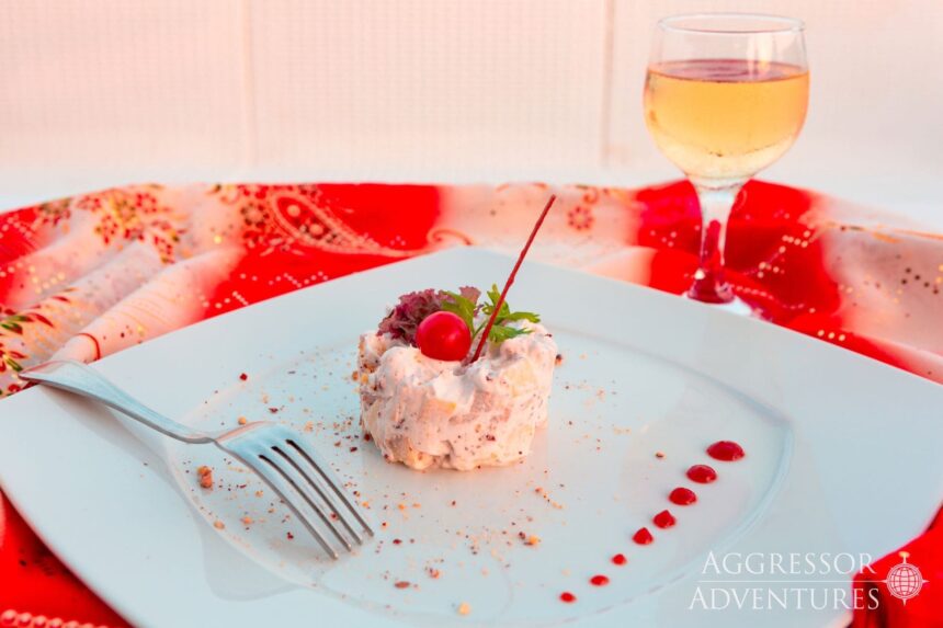 Molded fruit dessert plated beside a glass of white wine aboard the Red Sea Aggressor II