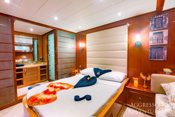 Wood paneled cabin on the Red Sea Aggressor II with a made-up double bed