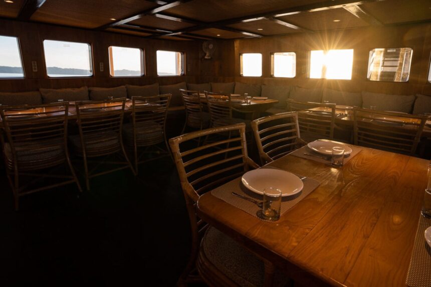 Dining tables set with plates and glasses aboard the Pindito liveaboard