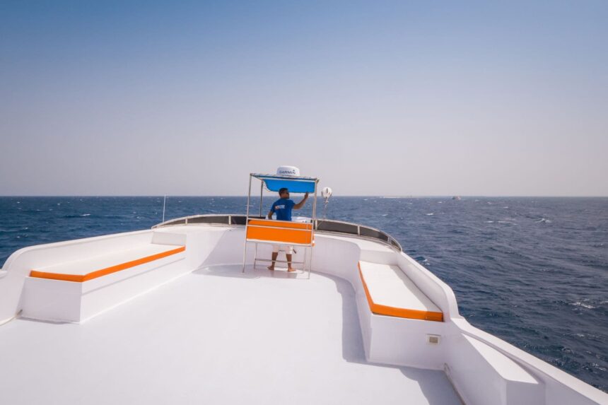 Crew member standing at the bow of the Emperor Asmaa under open sky