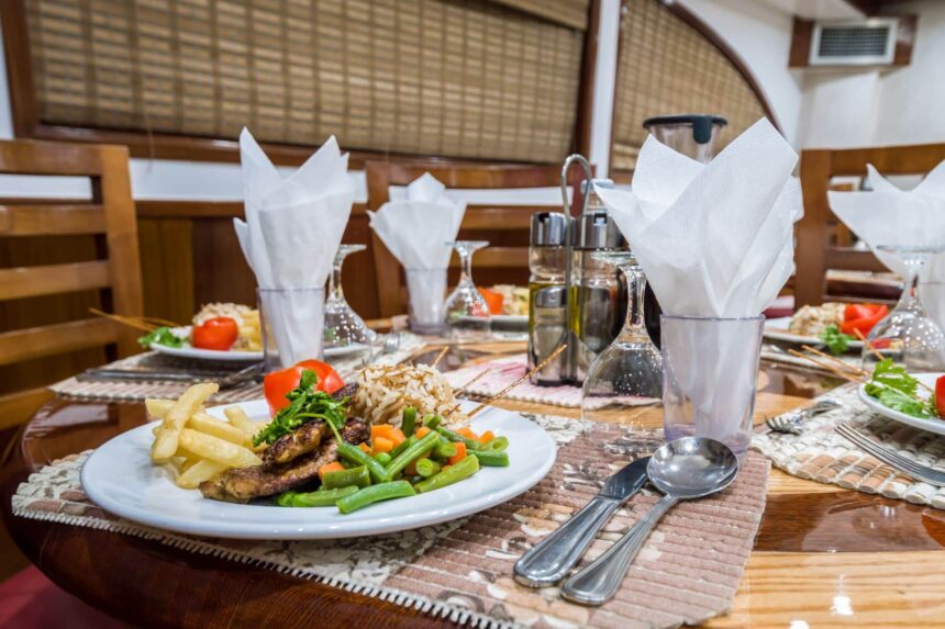 Plate of grilled meat with fries and vegetables set on the Emperor Asmaa's dining table