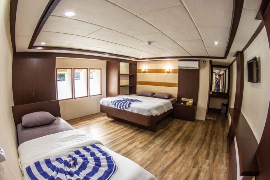 Twin cabin aboard the Emperor Serenity with striped towels and wood interior
