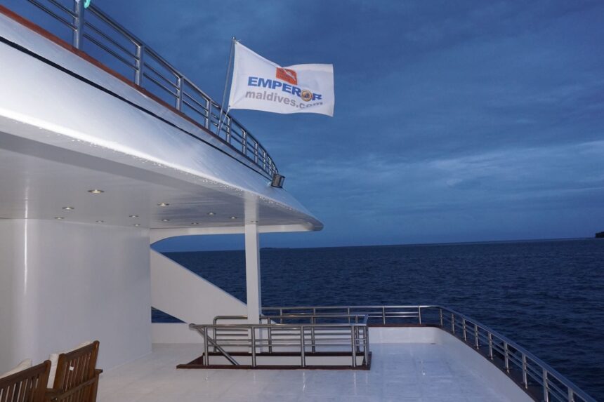 Emperor Maldives flag flying from the top deck at dusk