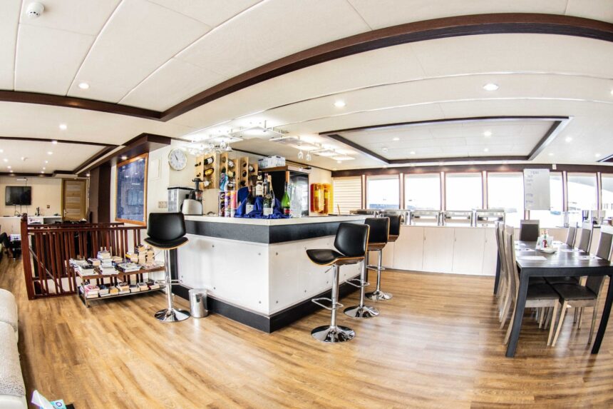 Bar and lounge area aboard the Emperor Serenity with sofas and dining tables