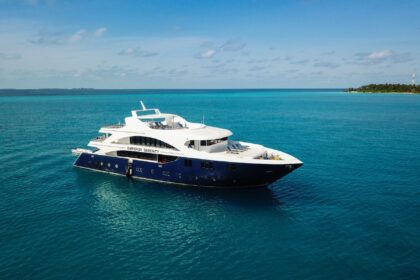 Emperor Serenity liveaboard yacht anchored in turquoise water near a tropical island