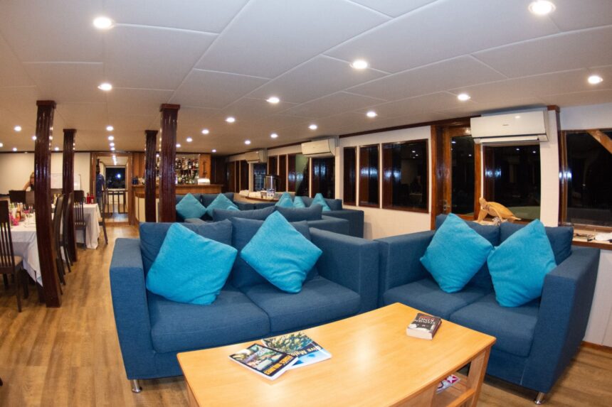 Blue lounge seating with teal cushions aboard the Emperor Leo at night