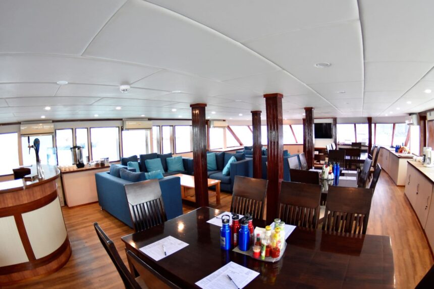 Saloon aboard the Emperor Leo with dark wood columns, sofas and dining tables