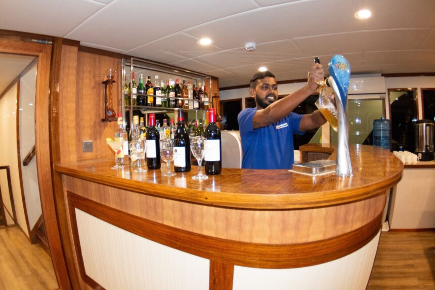 Bartender filling a glass from the tap behind the Emperor Leo's bar