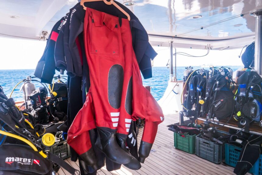 Red drysuit and wetsuits hanging to dry on the Emperor Superior's dive deck