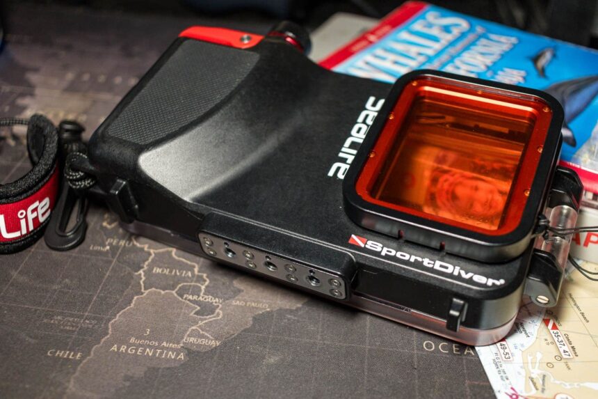 SeaLife SportDiver smartphone housing resting on a map-print desk with its red filter fitted