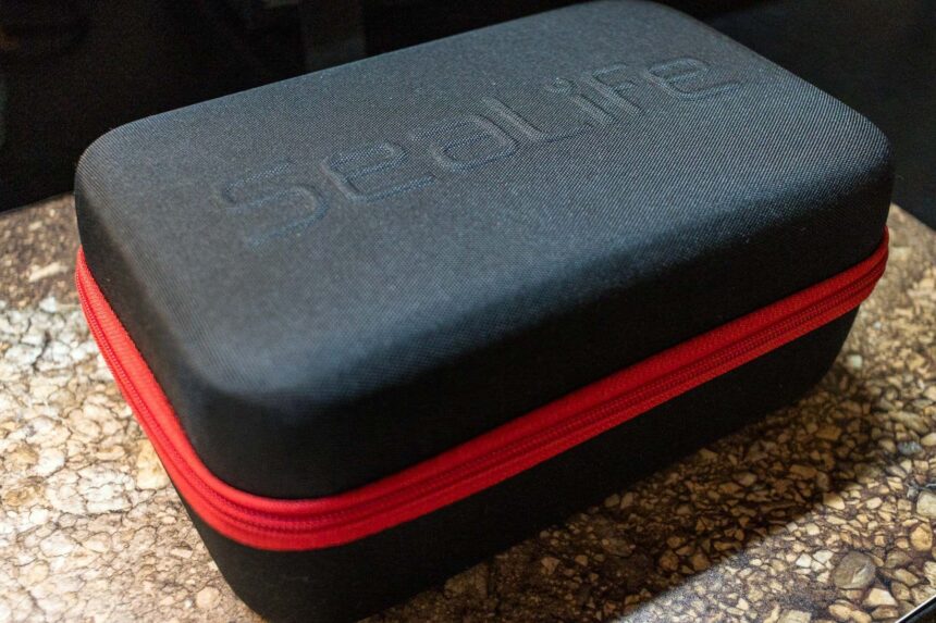 Black SeaLife hard travel case with a red zipper, closed on a countertop