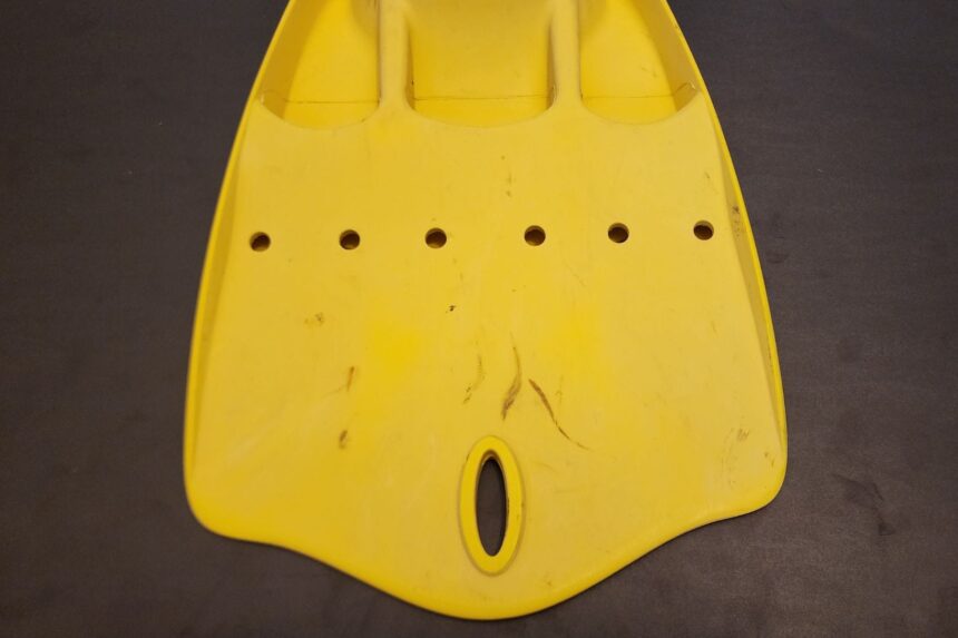 Blade tip of a yellow ScubaPro Jet Fin with its row of vent holes and oval slot