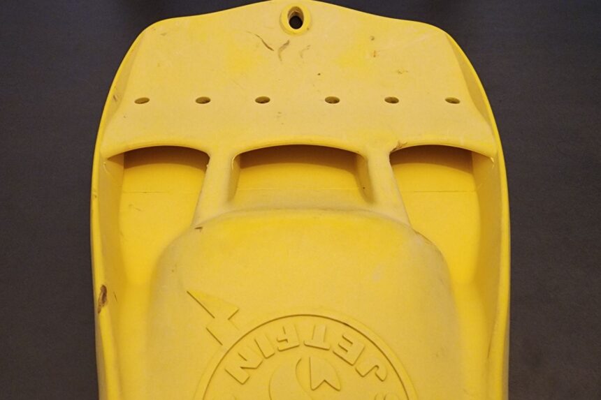 Underside of a yellow ScubaPro Jet Fin showing the vent holes and molded logo on the foot pocket