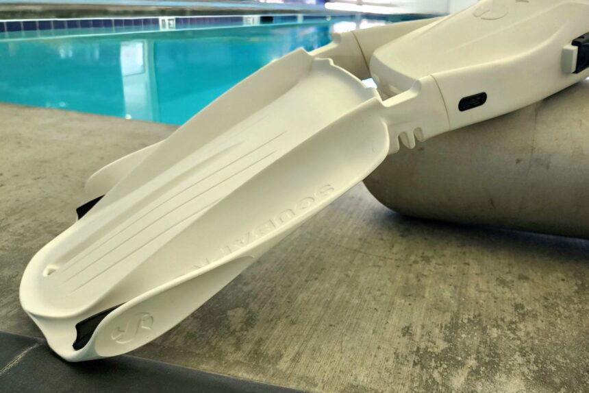 White ScubaPro Seawing Supernova fins propped at the poolside with the hinged blade section visible