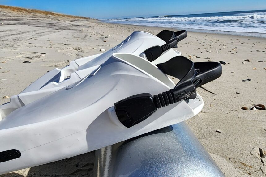 Heavy-duty black bungee straps on the white ScubaPro Seawing Supernova fins on a sandy beach