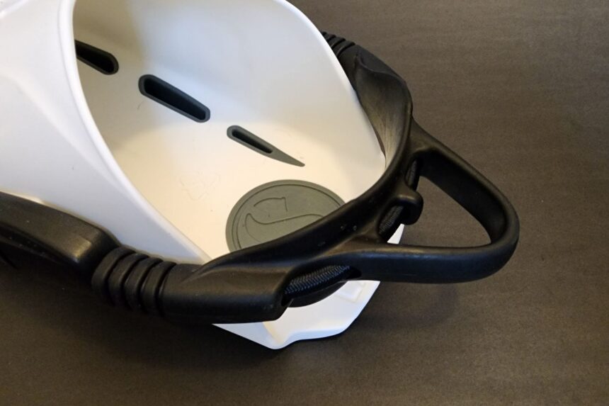 Close-up of the black bungee heel strap and swivel mount on a white Seawing Supernova foot pocket