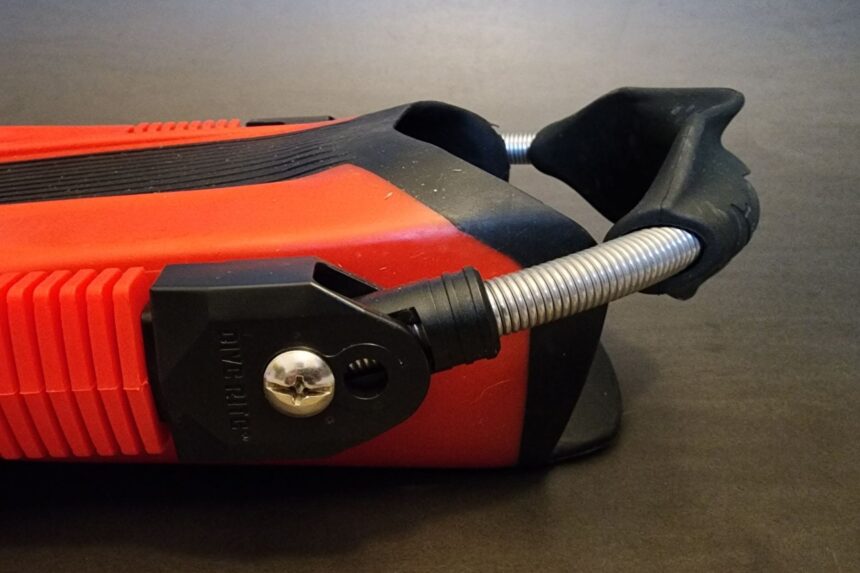Close-up of the stainless spring strap bolted into the side of the red Dive Rite XT fin