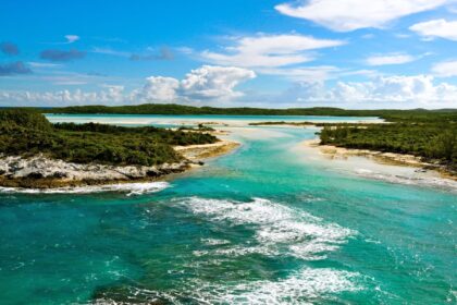 Aerial view of a turquoise tidal channel cutting between low scrub islands at Columbus Point, Bahamas