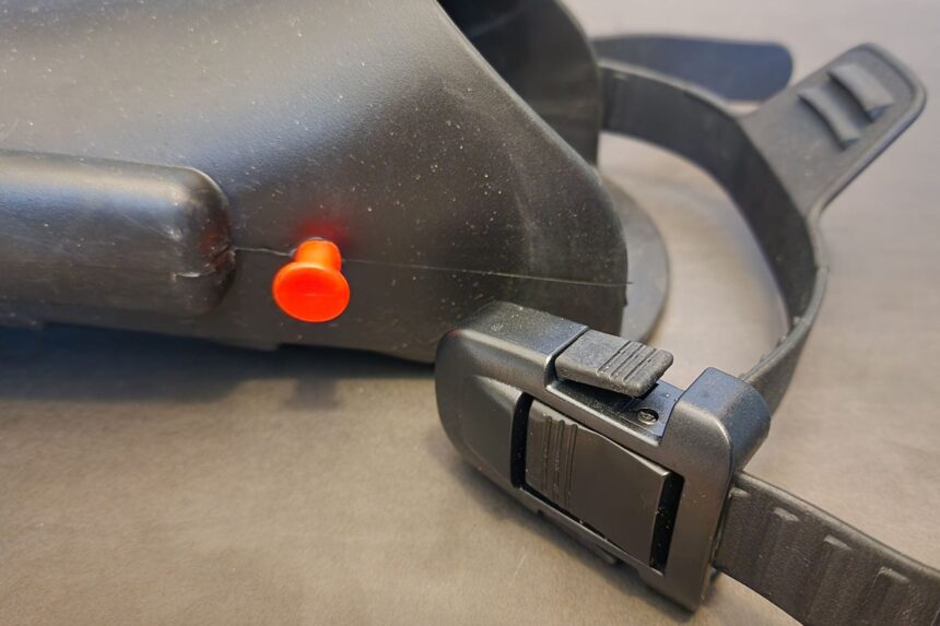 Close-up of the orange EZ-LOK release button and quick-release buckle on an Atomic Aquatics SplitFin