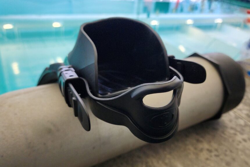 TUSA Solla foot pocket and adjustable strap balanced on a scuba cylinder by the pool