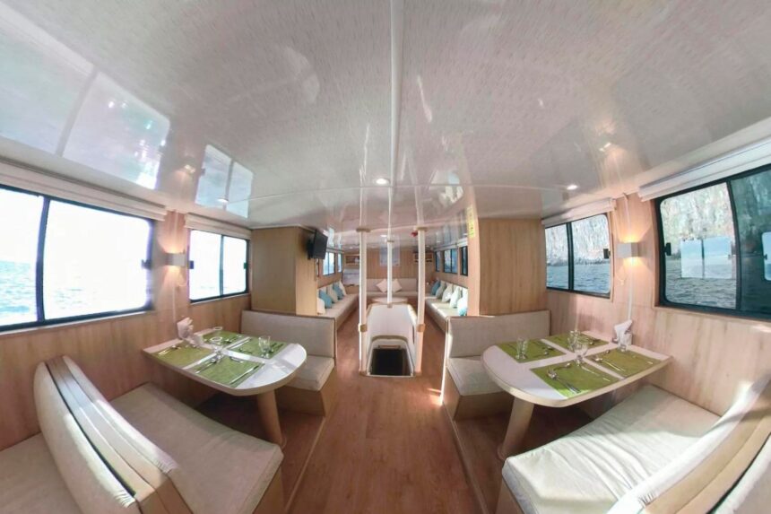 Dining tables set with placemats and glasses inside the Aqua liveaboard