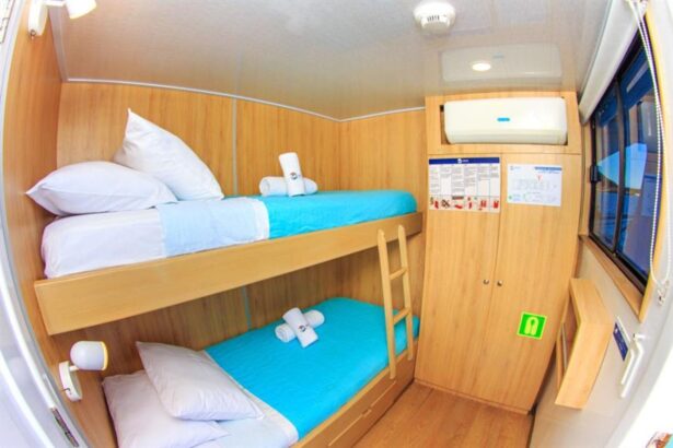 Bunk bed cabin on the Aqua with turquoise linens and towels rolled on the beds