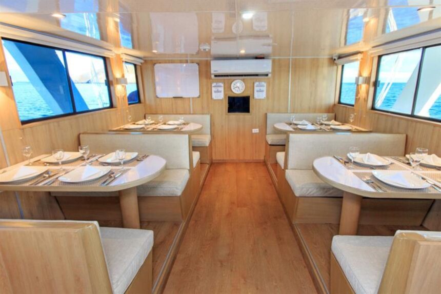 Dining booths with place settings inside the Aqua liveaboard's restaurant