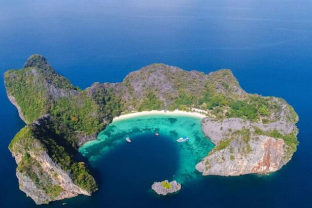 Aerial view of a tropical island lagoon with boats near a white sand beach