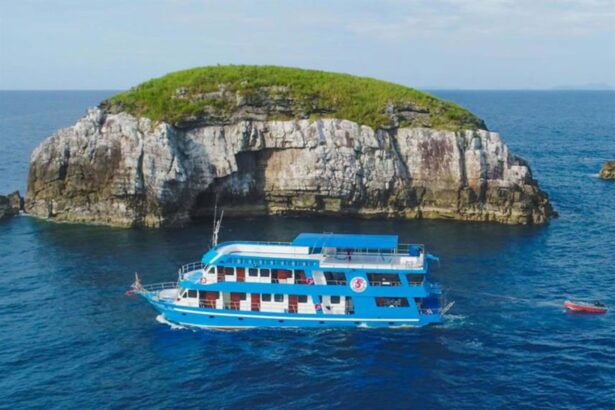 The Smiling Seahorse liveaboard anchored beside a rocky, jungle-topped island