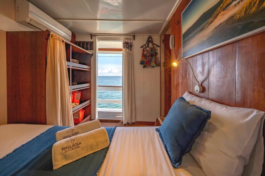 Ambai liveaboard dive tender loaded with divers and scuba tanks alongside the mothership