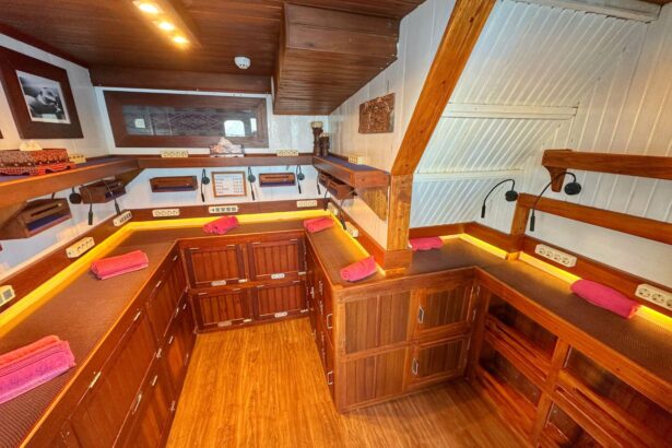 Bunk cabin aboard the Ambai with a gold-trimmed bed and wall tapestry