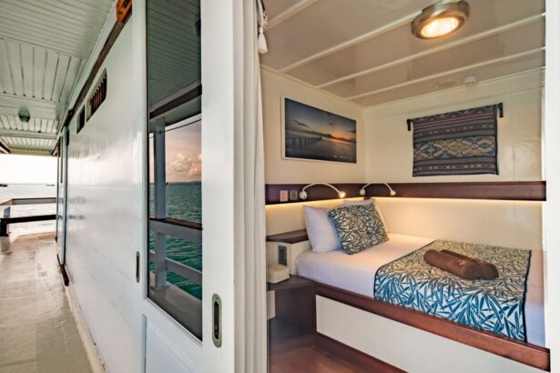 Indoor lounge with staircase and wicker seating aboard the Ambai