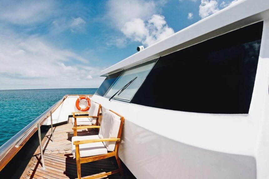 wooden deck chairs and a life ring at the bow of the Galapagos Sky