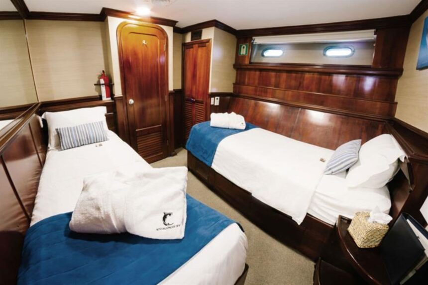 twin cabin with two beds and folded towel robes aboard the Galapagos Sky