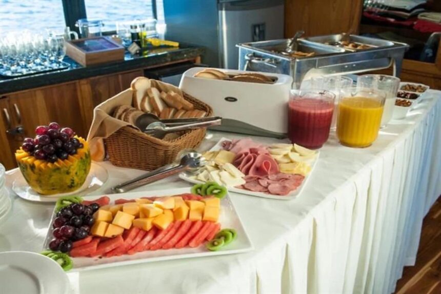 breakfast buffet spread with fruit, cold cuts, and juices on the Galapagos Sky