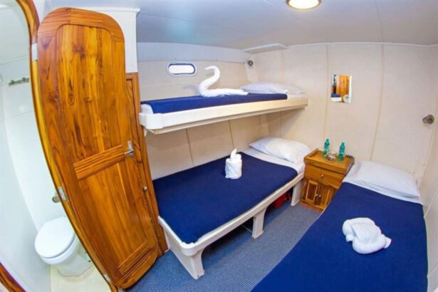 cabin aboard the Nortada with a bunk bed and two lower berths decorated with towel swans