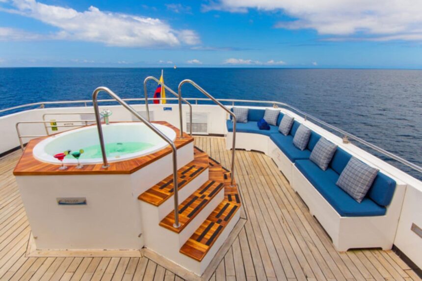 a hot tub and blue-cushioned lounge seating on the Calipso's sundeck