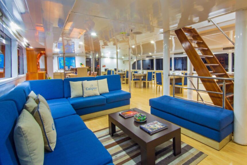 the Calipso's onboard lounge with blue sofas, dining tables and a stairway