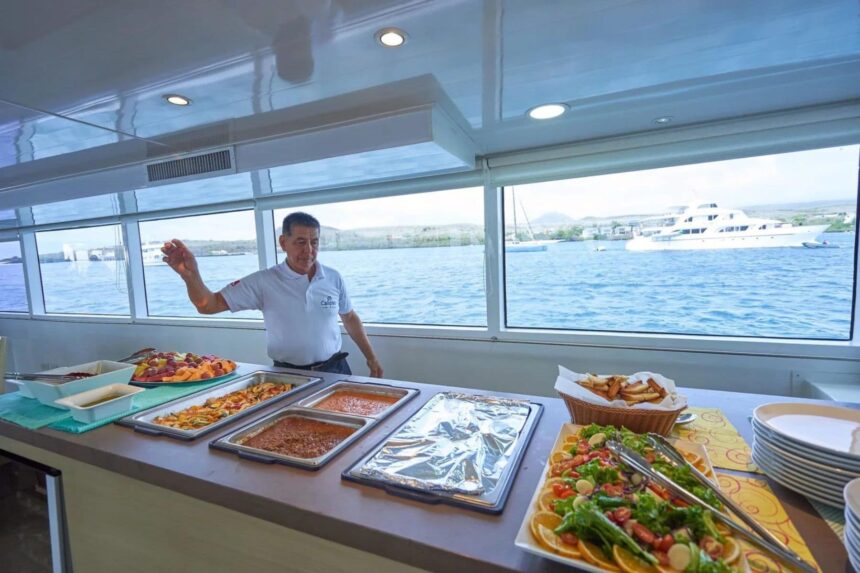 a crew member serves a buffet spread of salads and hot dishes onboard