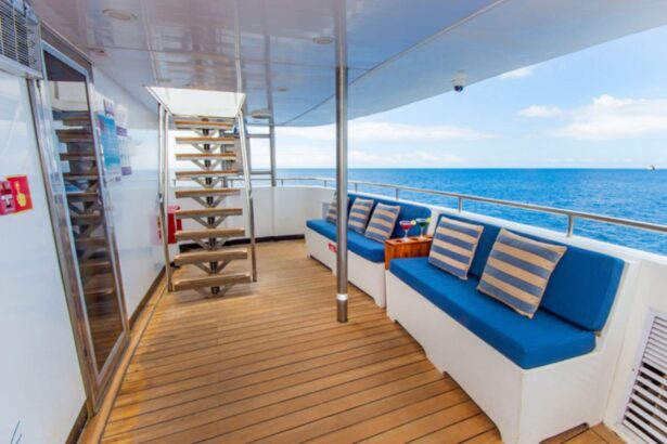 a covered deck seating area with striped cushions overlooks the water