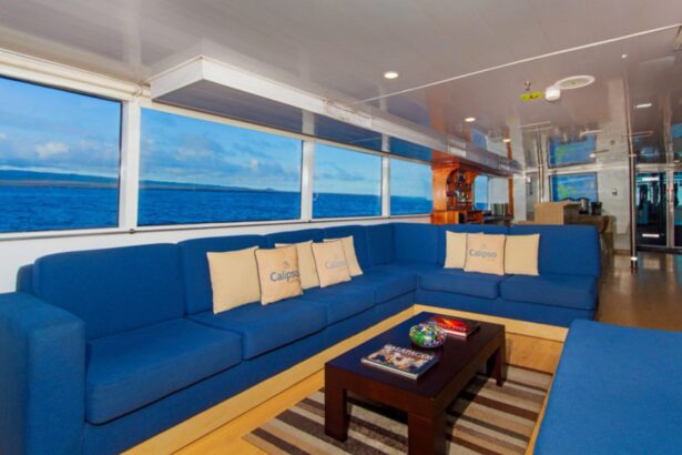 a blue sectional sofa with Calipso branded pillows in the onboard lounge